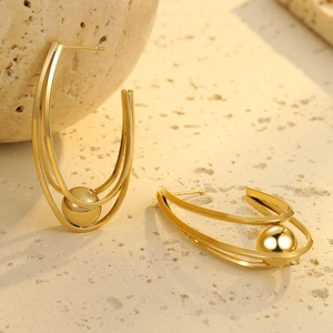 Detail von vergoldeten Dreifachring-Ohrringen mit einer zentralen hochglanzpolierten Metallperle