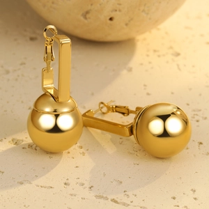 Polierte goldene Edelstahl-Ohrringe mit geometrischen Haken auf Naturstein