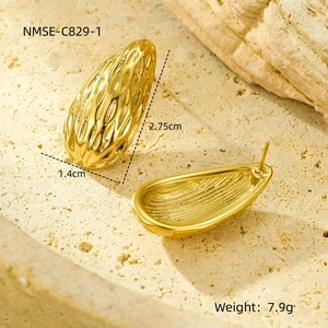 Vista macro de pendientes dorados 18K con textura de gota de agua y relieve en 3D