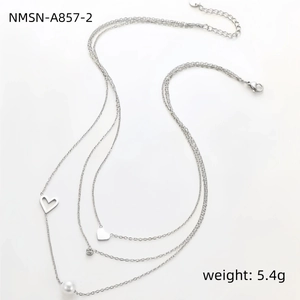 Detail van een drielaagse roestvrijstalen hartjesketting met parels en kralen