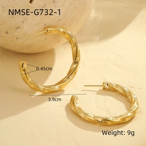 Détail macro des boucles d'oreilles en C torsadées dorées avec spécifications NMSE-G732-1