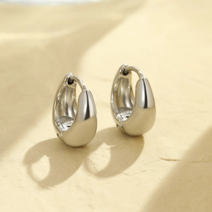 Macro view of polished silver water drop earrings with vintage minimalist clasp design