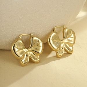 Vue détaillée des boucles d'oreilles papillon dorées avec motifs de nervures gravés