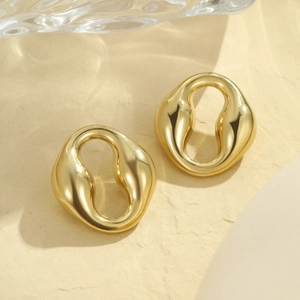 Détail de boucles d'oreilles ovales dorées avec une finition miroir brillante