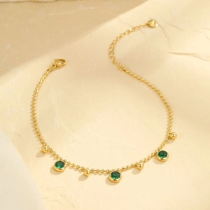 Multilayer stainless steel gold beaded anklet featuring three emerald green gemstones