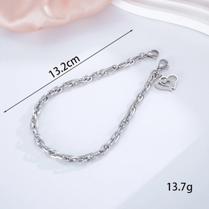 Detail of silver stainless steel charm chain with heart pendants on pink silk background