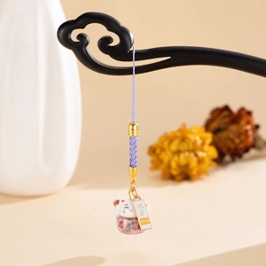 Detail of ceramic pink flower lucky cat charm with purple woven cord and golden clasp