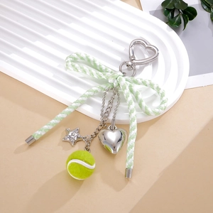 Detail van groene geweven strik tas hanger met tennisbal en zilveren hangers