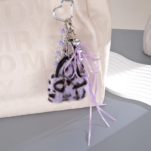 Plüschiger Taschenanhänger mit lila Leopardenmuster, Perlenkette und Schleife