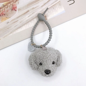 Close-up of a grey plush teddy dog keychain with a silicone strap and heart tag