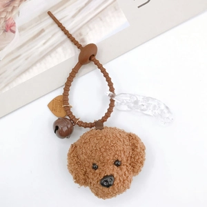 Detail of plush Teddy dog charm with silicone strap, bell, and brown heart-shaped tag