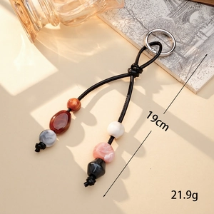 Detail of colorful acrylic beaded charm with hand-woven rope and silver metal ring