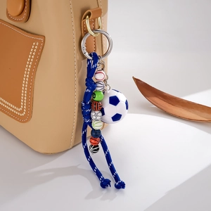 Detail of hand-woven nylon rope pendant with multi-sport ball beads on leather bag
