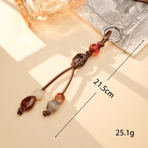 Macro detail of handmade beaded bag charm with PU leather cord and acrylic beads