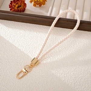 Close-up of cream hand-woven phone wrist strap with a polished gold lobster clasp