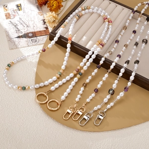Chic handmade pearl crossbody phone chain strap with colorful beads on a velvet tray