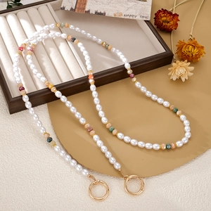 Détail d'une longue lanière perlée colorée avec perles et fermoirs à ressort dorés