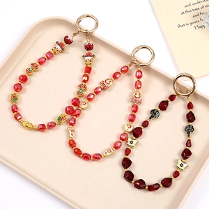 Dragonne de téléphone en perles de cristal rouge fait main avec breloques et boucles d'or