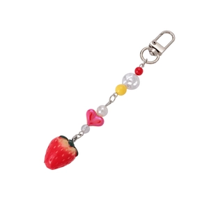 Handmade beaded keychain with red strawberry pendant and heart bead on white background