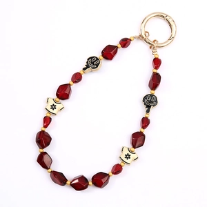Red crystal beaded phone strap with cute T-shirt and ghost charms on gold spring ring