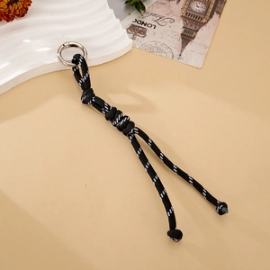 Detail shot of a handmade black and white woven paracord keychain with a silver spring clip