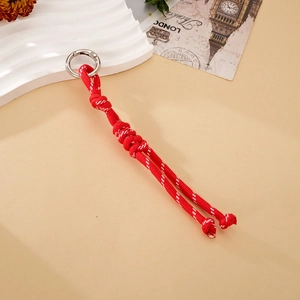 Detail of red woven nylon lanyard with silver spring ring on decorative tray