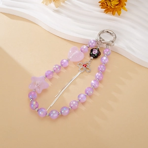 Détail de la dragonne de téléphone en perles violettes avec trèfle et coeur rose