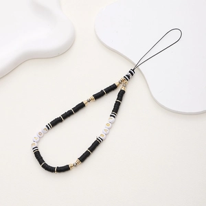 Detail of beaded phone strap with LOVE letter beads and black clay discs on white prop