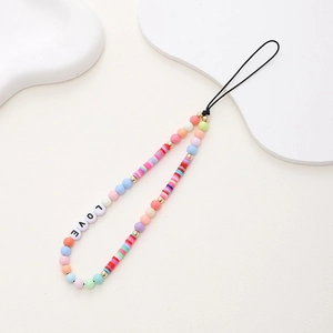 Macro detail of handmade beaded phone strap featuring LOVE letter beads and clay discs