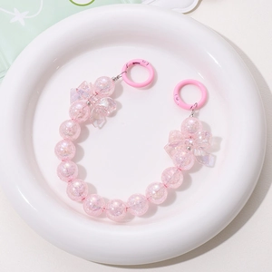 Detailed view of pink bow beads and cracked glitter spheres in a bead chain for bags