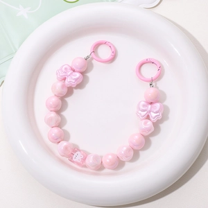 Close-up of pink faux pearl phone chain with bow beads and cute rabbit charm detail