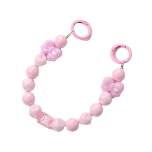 Pink beaded phone charm with bow and white rabbit beads on white background