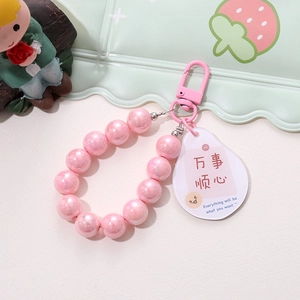 Pink pearlescent beaded keychain with metal spring hook and a white tag with blessing
