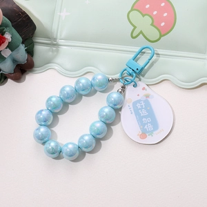 Detail of light blue pearlescent bead keychain with acrylic tag and metal D-ring buckle