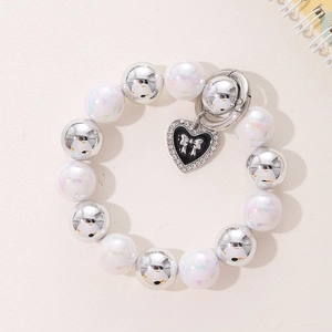 Bracelet en perles argentées et nacrées blanches avec pendentif cœur noir et nœud