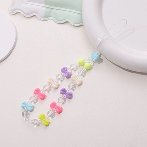Detail of colorful macaron beaded phone strap with bow tie beads on white surface