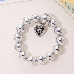Détail du bracelet de téléphone en perles argentées avec pendentif cœur et nœud émaillé