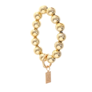 Bracelet à perles dorées polies avec pendentif pièce portrait vintage sur fond blanc