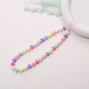 Close-up of colorful heart resin beads and white pearls on a sweet style phone strap