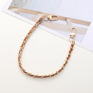 Detail of gold metal and brown leather woven chain strap with lobster clasps