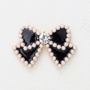 Elegant gold bow charm with black enamel, white pearls and a large center crystal