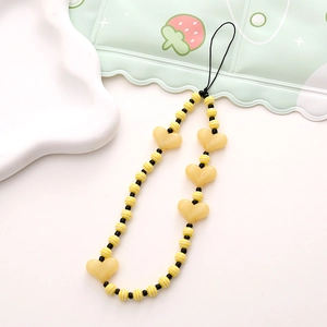 Detail of handmade beaded phone strap with yellow hearts and striped beads
