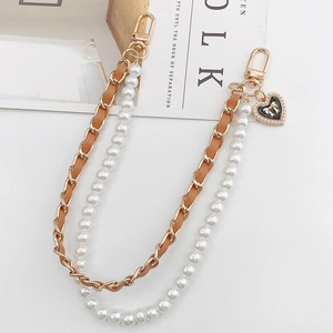 Detail of dual leather-metal chain and pearl strap with black heart bow pendant