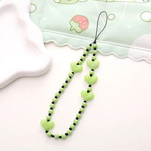 Close-up of green and white striped beads and heart charms on a short phone lanyard
