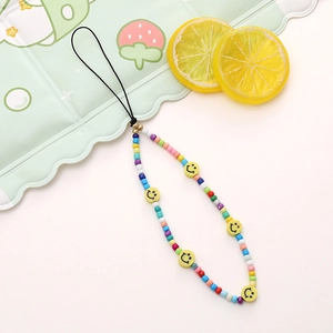 Detail view of colorful beaded phone strap with yellow smiley face beads and gold accents