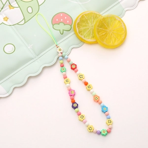 Detailed shot of handmade colorful beaded phone wrist strap with smiley face flower charms