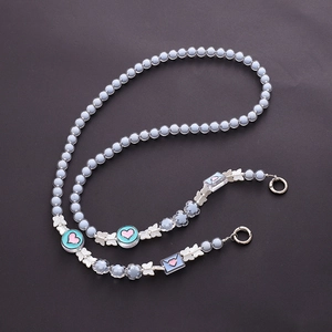 Detail of light blue beaded phone strap with silver bow and heart envelope pendants