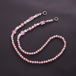 Close-up of pink acrylic beads with silver butterfly charms and heart patterns