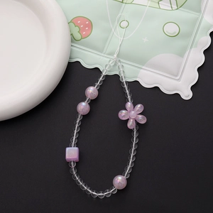 Detail view of pearlescent purple beads and floral charms on a handmade phone lanyard
