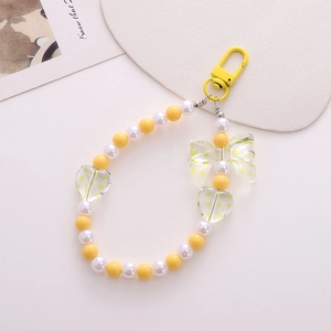 Detail of yellow flower keychain with polka dot bow beads and heart charms